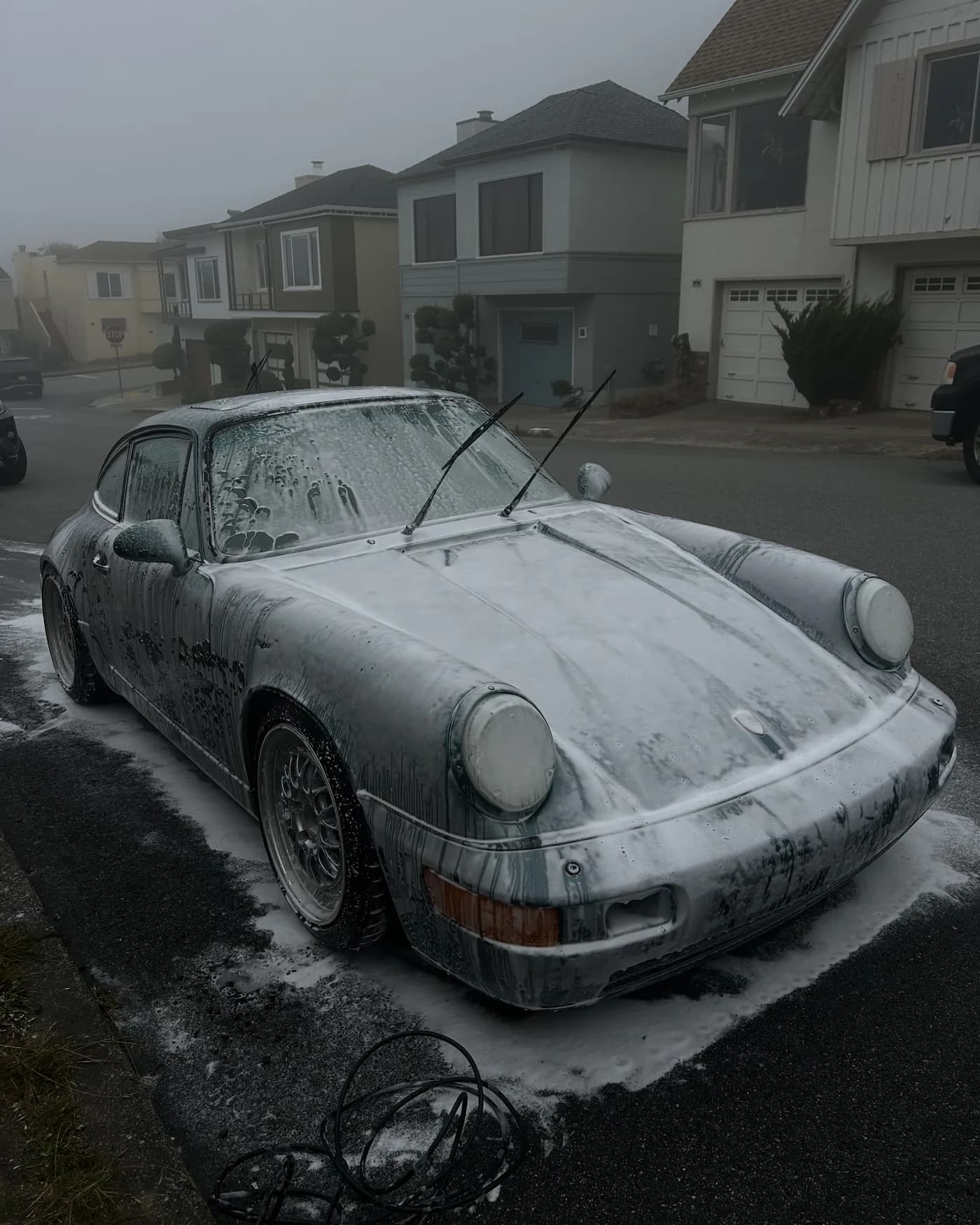 Porsche 964 covered in snow foam during a wash